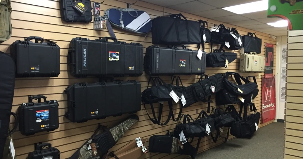 Protective cases and firearm bags displayed on a shop wall at Coyote Point Armory