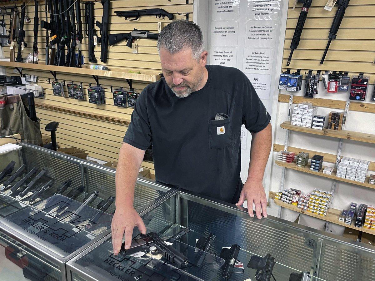 Coyote Point Armory team member behind the glass display counter